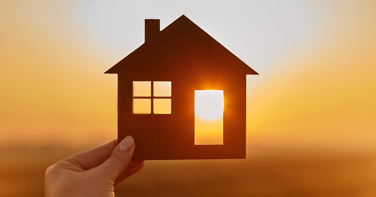 cutout of a house against a sunset